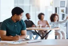Reject, sad and antisocial professional employee sitting at his desk as outcast in the workplace. Workplace Microaggressions concept