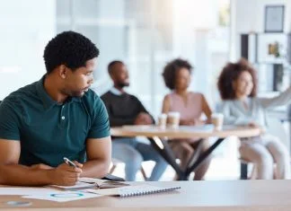 Breaking the Silence: How Organisations Can Dismantle Cultures that Sustain Microaggressions Reject, sad and antisocial professional employee sitting at his desk as outcast in the workplace. Workplace Microaggressions concept