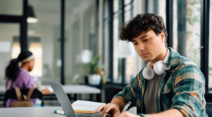 Student writing while utilizing Assignment Writing Services