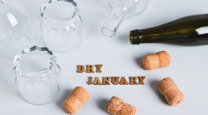 Dry January is Popular, But Approach With Caution, Says Expert Overturned glasses, empty bottles, corks and text dry january on gray background