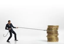 US Hard Money vs. European Bridging: Structural Differences in Asset-Backed Lending Businessman pulling stack of big golden coins with a rope isolated on white background. Making money. Profit and advantage. Earning a fortune.