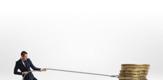 Businessman pulling stack of big golden coins with a rope isolated on white background. Making money. Profit and advantage. Earning a fortune.