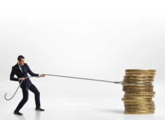 Businessman pulling stack of big golden coins with a rope isolated on white background. Making money. Profit and advantage. Earning a fortune.