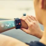 How Health Tech Innovations are Revolutionizing Healthcare Systems in Europe Young woman checking the sports watch with screen, Health Tech icon, measuring heart rate and performance after running.