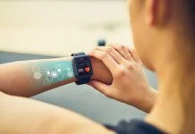 Young woman checking the sports watch with screen, Health Tech icon, measuring heart rate and performance after running.