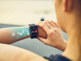 Young woman checking the sports watch with screen, Health Tech icon, measuring heart rate and performance after running.