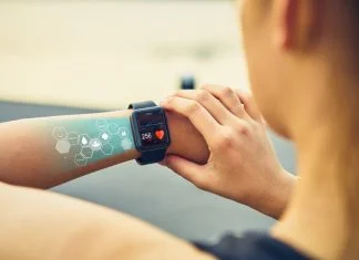 Young woman checking the sports watch with screen, Health Tech icon, measuring heart rate and performance after running.