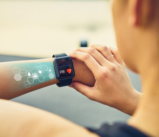 Young woman checking the sports watch with screen, Health Tech icon, measuring heart rate and performance after running.