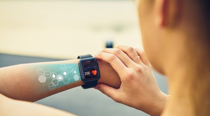 Young woman checking the sports watch with screen, Health Tech icon, measuring heart rate and performance after running.