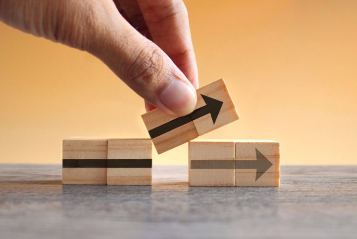 New strategy, changes, alternative path, and improvement Hand holding wooden cubes with arrow icon. New strategy, changes, alternative path, and improvement. Small Changes for Big Business concept