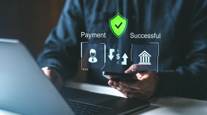 Digital payment process with holographic icons on a dark background. A person using a smartphone and laptop with holographic payment icons, secure shield, and success symbols. Concept of secure online payment