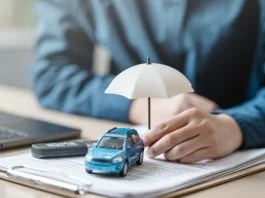 Car insurance protect concept. Insurance agent. Insurance protection concept. A person is holding a blue car under an umbrella. The umbrella is white and is placed on top of a piece of paper.