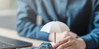 Car insurance protect concept. Insurance agent. Insurance protection concept. A person is holding a blue car under an umbrella. The umbrella is white and is placed on top of a piece of paper.