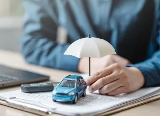 Car insurance protect concept. Insurance agent. Insurance protection concept. A person is holding a blue car under an umbrella. The umbrella is white and is placed on top of a piece of paper.