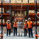 Gain Founder Freedom in 2026: Solve SMB Capacity Challenges Logistics manager explaining and delegating operations to warehouse workers. Solve SMB Capacity Challenges