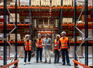 Logistics manager explaining and delegating operations to warehouse workers. Solve SMB Capacity Challenges