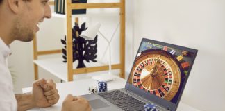 Discovering the Next Era of Digital Interactive Play at GameZone Casino Happy, excited man sitting at table with poker chips and looking at casino wheel on screen on GameZone Casino app