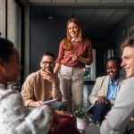 A group of motivated professionals sharing ideas, laughter, engagement, collaboration and collaboration in a bright office space, reflecting teamwork and creativity in a business environment.