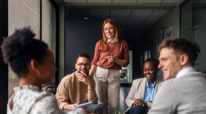 A group of motivated professionals sharing ideas, laughter, engagement, collaboration and collaboration in a bright office space, reflecting teamwork and creativity in a business environment.