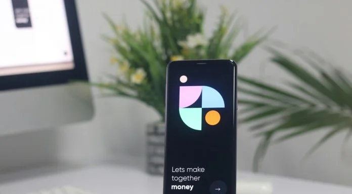 a cell phone sitting on top of a stand on a desk for buying bitcoin