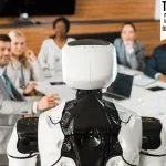 AI: The Boardroom’s Blind Spot selective focus of multicultural businesspeople looking at AI robot in conference hall