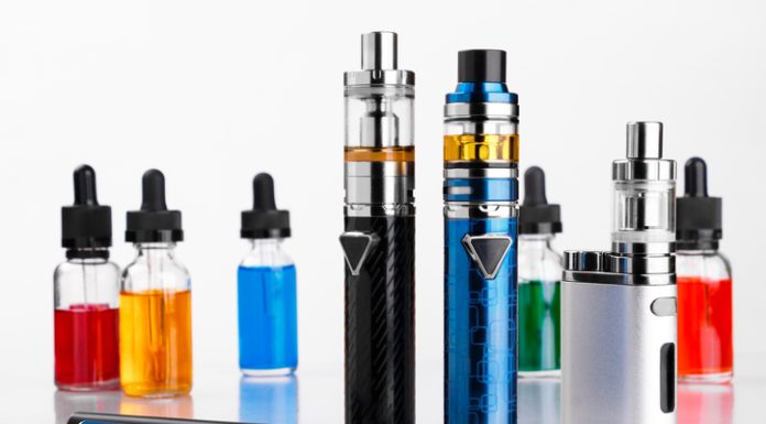 Modern electronic cigarettes, tobacco and bottles with assorted vape liquid on white background