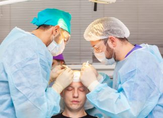 Baldness treatment. Hair transplant. Surgeons in the operating room carry out hair transplant surgery.