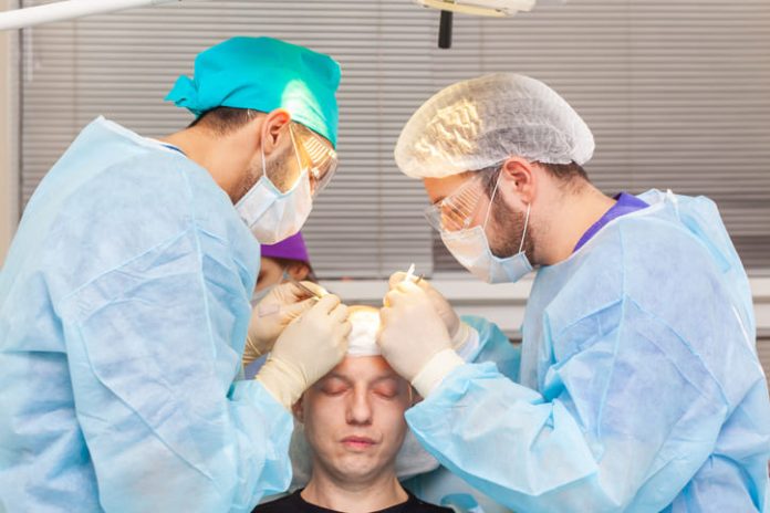 iStock-1157711475 (1) Baldness treatment. Hair transplant. Surgeons in the operating room carry out hair transplant surgery.