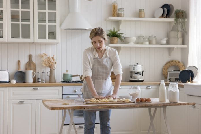 Calm pretty young baker woman in apron preparing pastry Trad Wife Movement