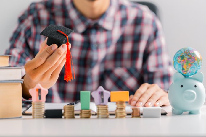 University graduate, holding their diploma and wearing cap and gown, celebrates their education with sense of accomplishment, ready to take on world. diverse, exchange, multicultural, foreign, learn Financial Independence Starts Earlier Than Most Students Think