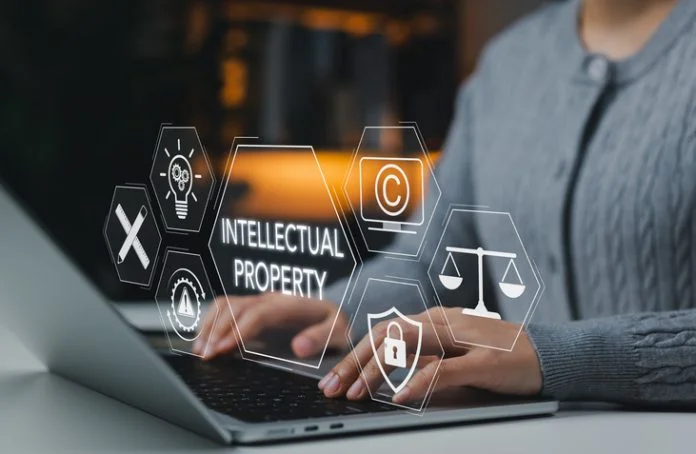 Intellectual property protection concept. Woman working on laptop with copyright, patent, security, and legal icons representing digital rights, trademark law, and creative ownership protection. Intellectual Property