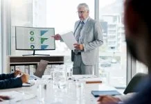 Businessman, screen and presentation with graphs in meeting for finance paperwork, kpi or planning.