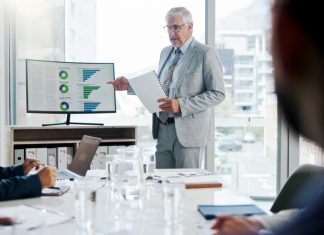 Businessman, screen and presentation with graphs in meeting for finance paperwork, kpi or planning.