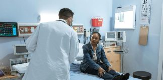 Doctor Talking to a Patient Sitting on Bed. Healthcare and the Workforce in US