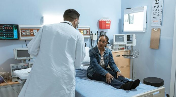 Doctor Talking to a Patient Sitting on Bed. Healthcare and the Workforce in US