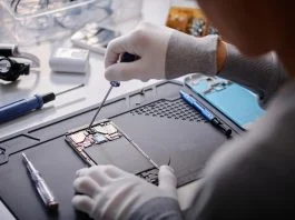 How to Test Phone Circuits Safely with a Magnetic Repair Mat and Professional Digital Multimeter Over shoulder shot of unrecognizable technician repairing disassembled smartphone, circuit with screwdriver