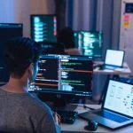 Software Development team working about coding promgram with software computer at night in office.