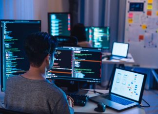 5 Things to Look for When Choosing a Software Dev Partner Software Development team working about coding promgram with software computer at night in office.