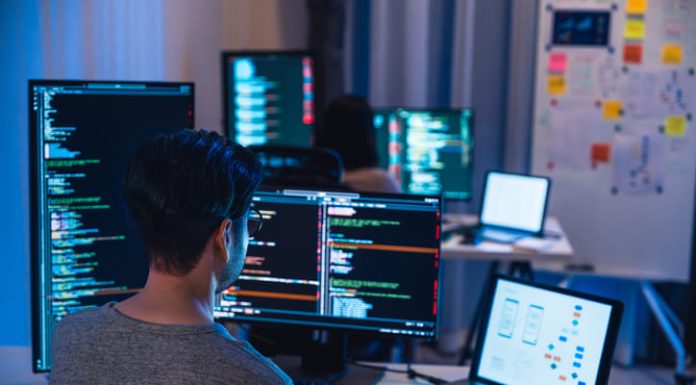 5 Things to Look for When Choosing a Software Dev Partner Software Development team working about coding promgram with software computer at night in office.