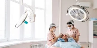 Professional trichologist surgeons carry out hair FUE Sapphire method hair transplant surgery in operating room to male patient with hair loss problem.