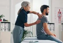 UK Musculoskeletal Crisis Costs NHS Billions: Custom Rehab Person, physical therapy on injury for rehabilitation or recovery of muscle damage in clinic. UK Musculoskeletal