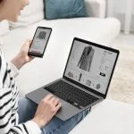 Woman with smartphone and laptop shopping online indoors or Multi-Platform Selling