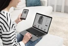 Woman with smartphone and laptop shopping online indoors or Multi-Platform Selling