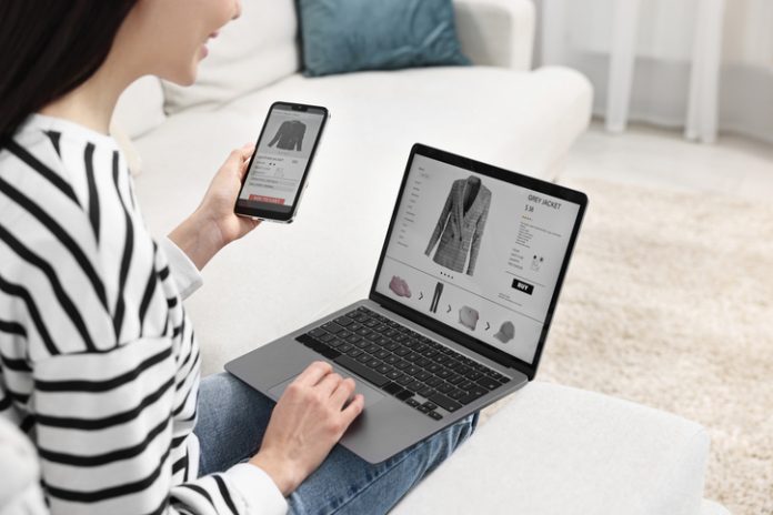 Woman with smartphone and laptop shopping online indoors or Multi-Platform Selling