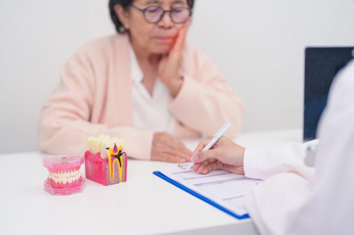 Elderly Patient consulting Dentist to Tooth disease, Senior Health Medical Diagnosis. Anatomy teeth model for Oral Teeth decay, Scrape off tartar. March Oral health, Dentist Day, False Teeth concept Wisdom Tooth Extraction for Seniors