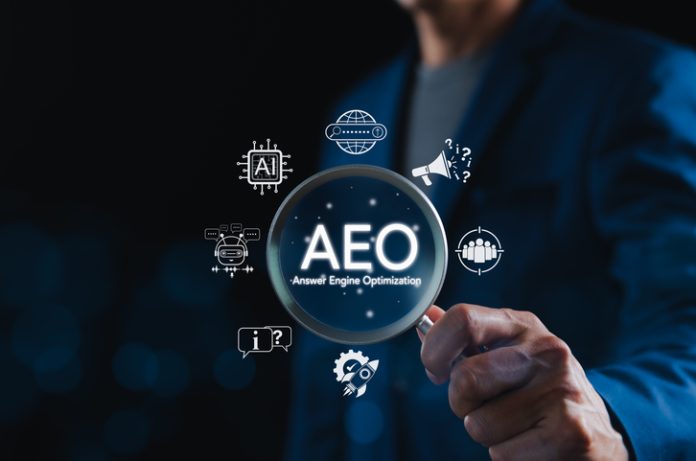 AEO Answer Engine Optimization Strategy Concept. Businessman holding magnifying glass with AEO icons, representing artificial intelligence, chatbots, search optimization, and marketing strategy. B2B AEO companies