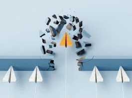 Fearless leader. Orange paper airplane breaking the wall barrier while others stuck, showing breakthrough, innovation, and leadership.