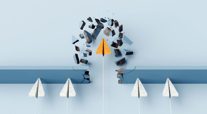 Fearless leader. Orange paper airplane breaking the wall barrier while others stuck, showing breakthrough, innovation, and leadership.