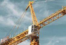 Yellow and black cranes during the day under cloudy skies