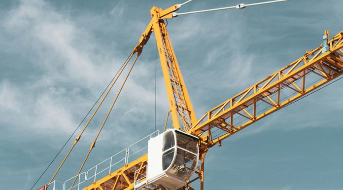 Yellow and black cranes during the day under cloudy skies
